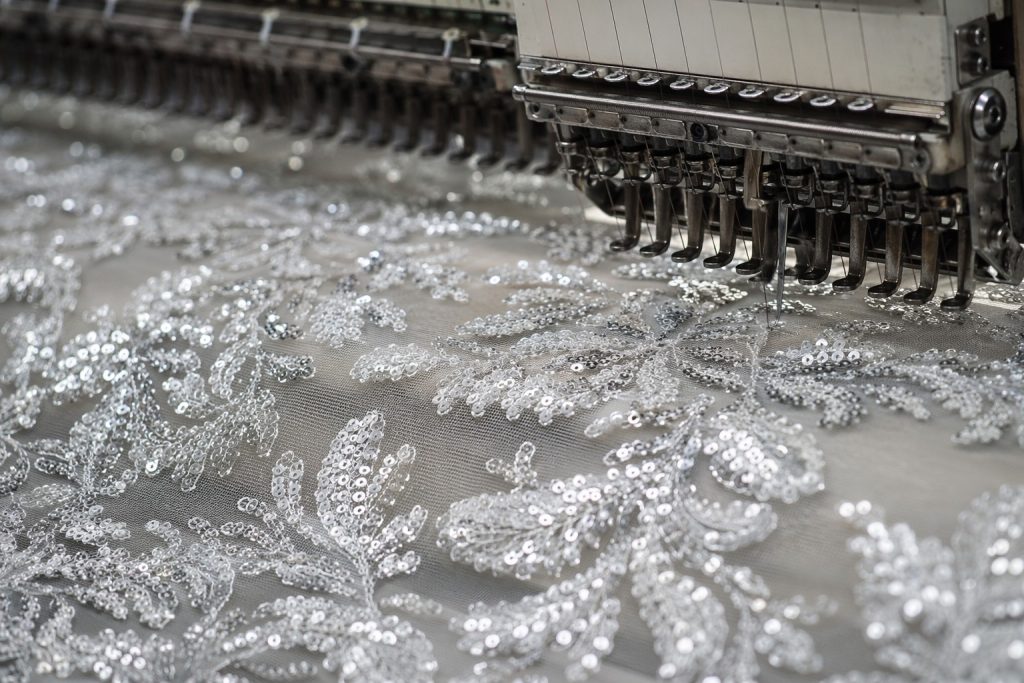 Industrial-grade sequin embroidery fabric under precision machine quality control