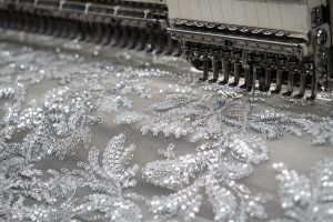 Industrial-grade sequin embroidery fabric under precision machine quality control