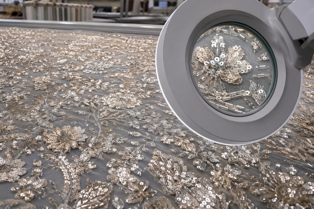High-density embroidered sequin fabric inspected for stitch precision
