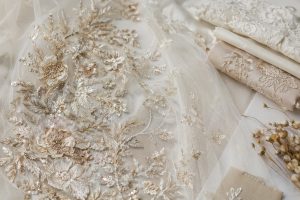 Asymmetrical botanical embroidery with champagne sequins on ivory bridal tulle