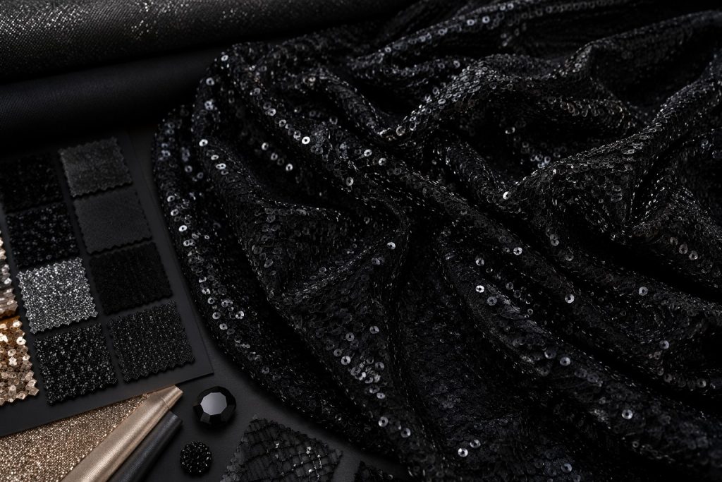 Black sequin fabric on mesh for luxury evening fashion and event supply