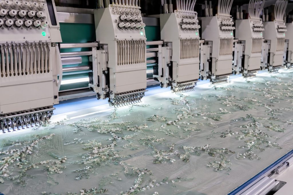 Multi-head embroidery machine producing precision sequin fabric patterns