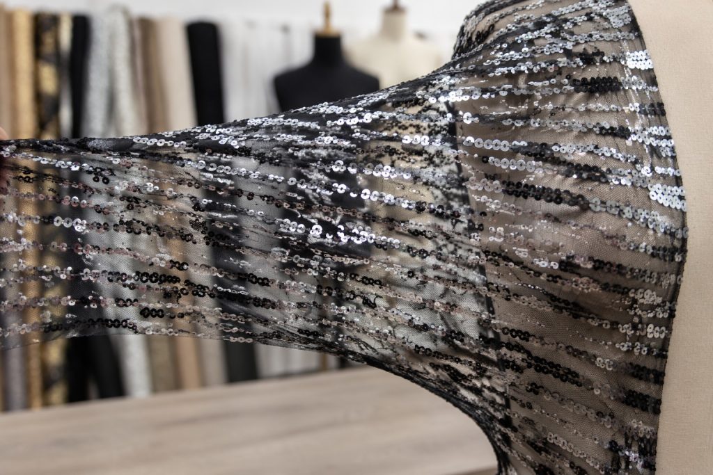 Stretch sequin mesh fabric showing elastic recovery for dancewear and fitted dress wholesale sourcing
