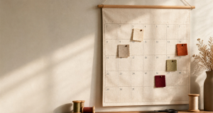 Aesthetic wall calendar with fabric swatches pinned to specific dates in seasonal light