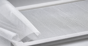Fine white 40D high-tenacity mesh fabric stretched on a light frame with the weave clearly visible on a clean technical surface