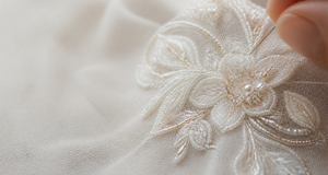 Close-up of delicate beads being sewn into a floral motif for bridal and eveningwear collections