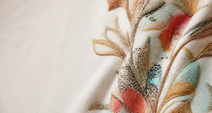 Fabric detail showing vibrant digital print with overlapping 3D embroidery threads