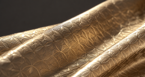 Shimmering embossed metallic foil fabric reflecting soft studio light