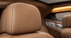 Luxury car interior leather headrest detail with custom tonal embroidery stitching