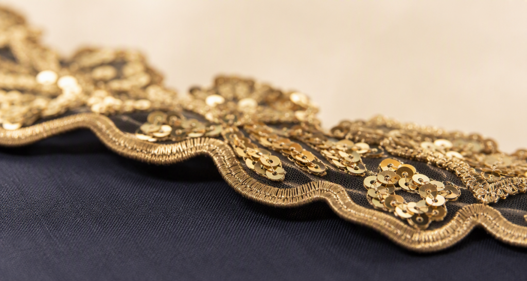 Macro of laser-cut appliqué edges with integrated sequins and embroidery stitches
