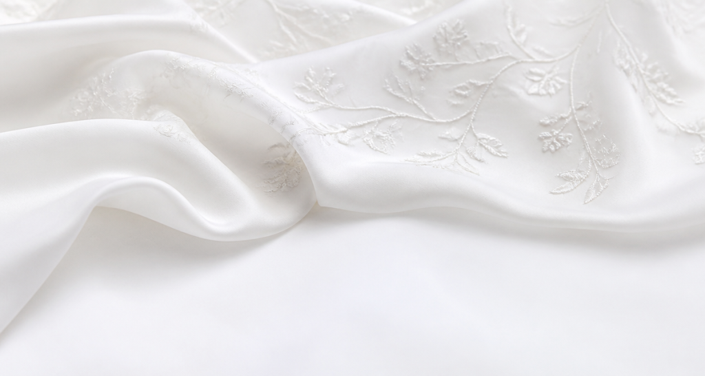 Pure minimal white embroidery pattern on high-end white silk fabric in soft folds