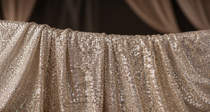 High-density sequin backdrop fabric in shimmering champagne and emerald tones for professional events and photography