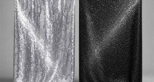 Side-by-side comparison of a silver sewn-sequin fabric panel and a black glitter fabric panel hanging from a wooden rod on a grey studio backdrop